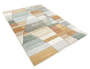 Moderner Webteppich in Pastellfarben mit geometrischem Muster, perspektivisch von der Seite fotografiert.