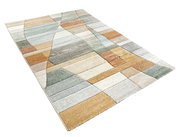 Moderner Webteppich in Pastellfarben mit geometrischem Muster, perspektivisch von der Seite fotografiert.