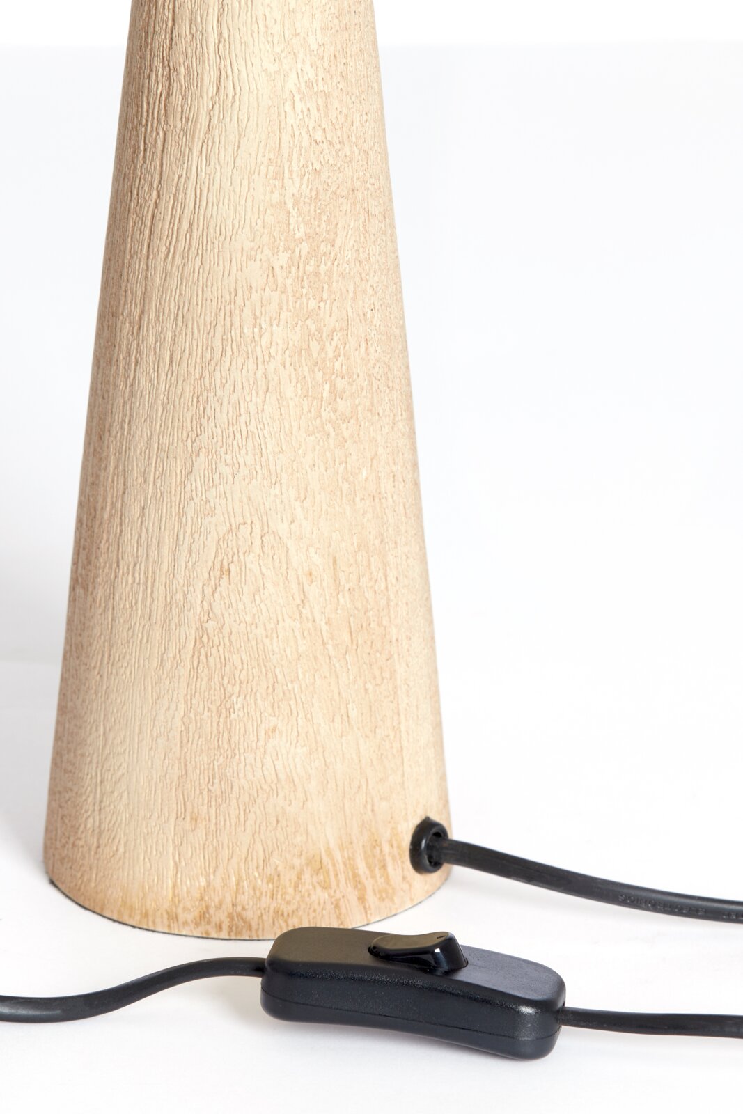 Close-up van een conische houten lampvoet met een zwarte kabel en schakelaar, gezien vanaf de zijkant.