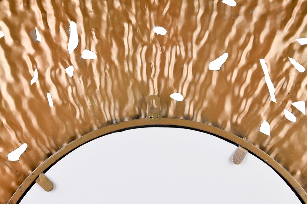 Close-up van een ronde spiegel met een decoratieve, golvende gouden lijst en uitgesneden details, gezien van bovenaf.