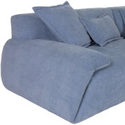 Ecksofa PONTO in hellblauem Stoff, seitliche Perspektive mit weichen Kissen.
