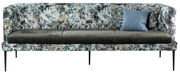 Moderne Bank mit gemustertem Stoffbezug und schwarzen Metallbeinen, frontal fotografiert. Inklusive zweier Kissen, eines in Blau und eines mit geometrischem Muster.