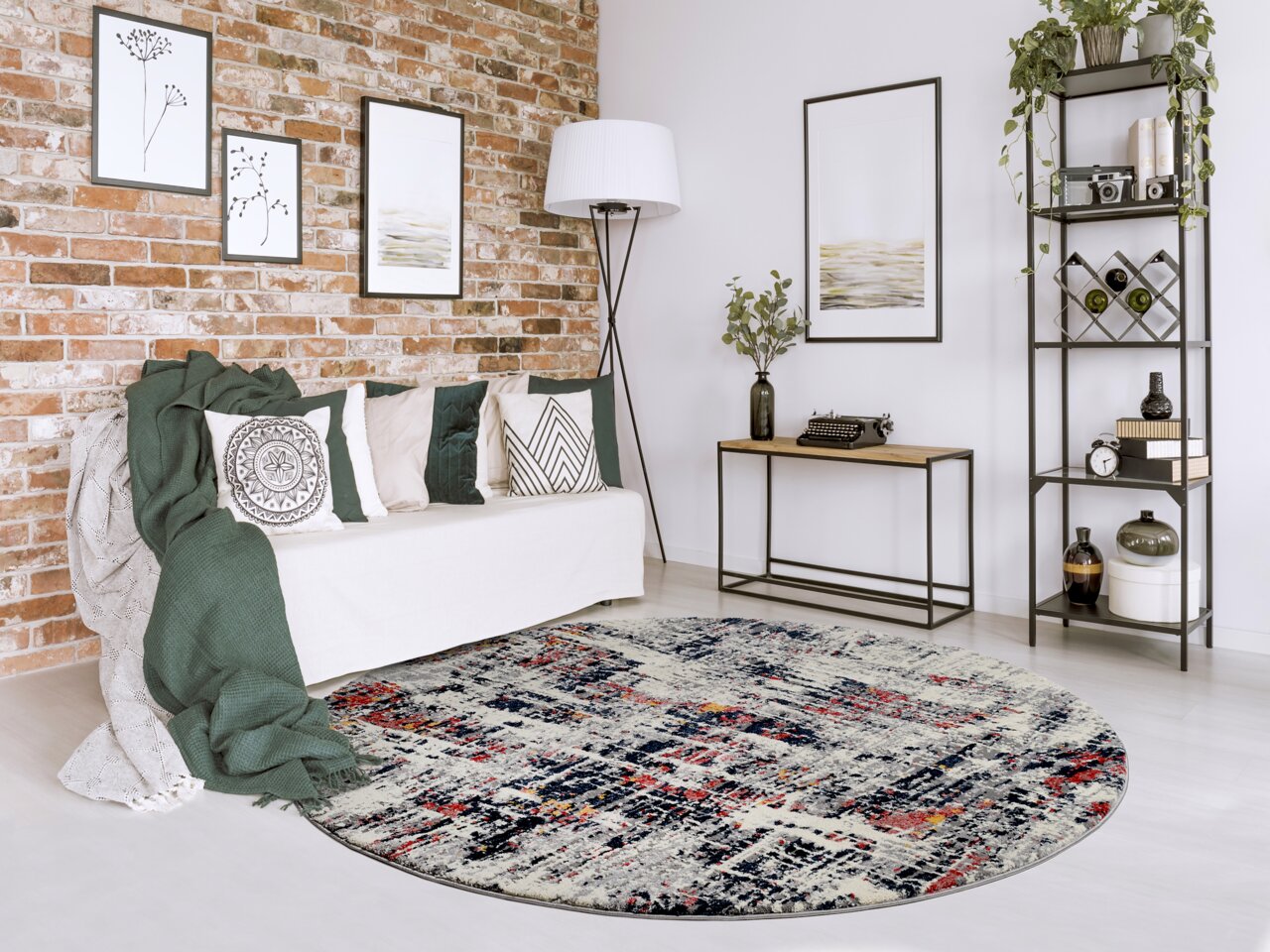 Runder Designer Teppich mit abstraktem Muster in einem modernen Wohnzimmer mit Backsteinwand, Sofa und Regal, aus der Vogelperspektive betrachtet.