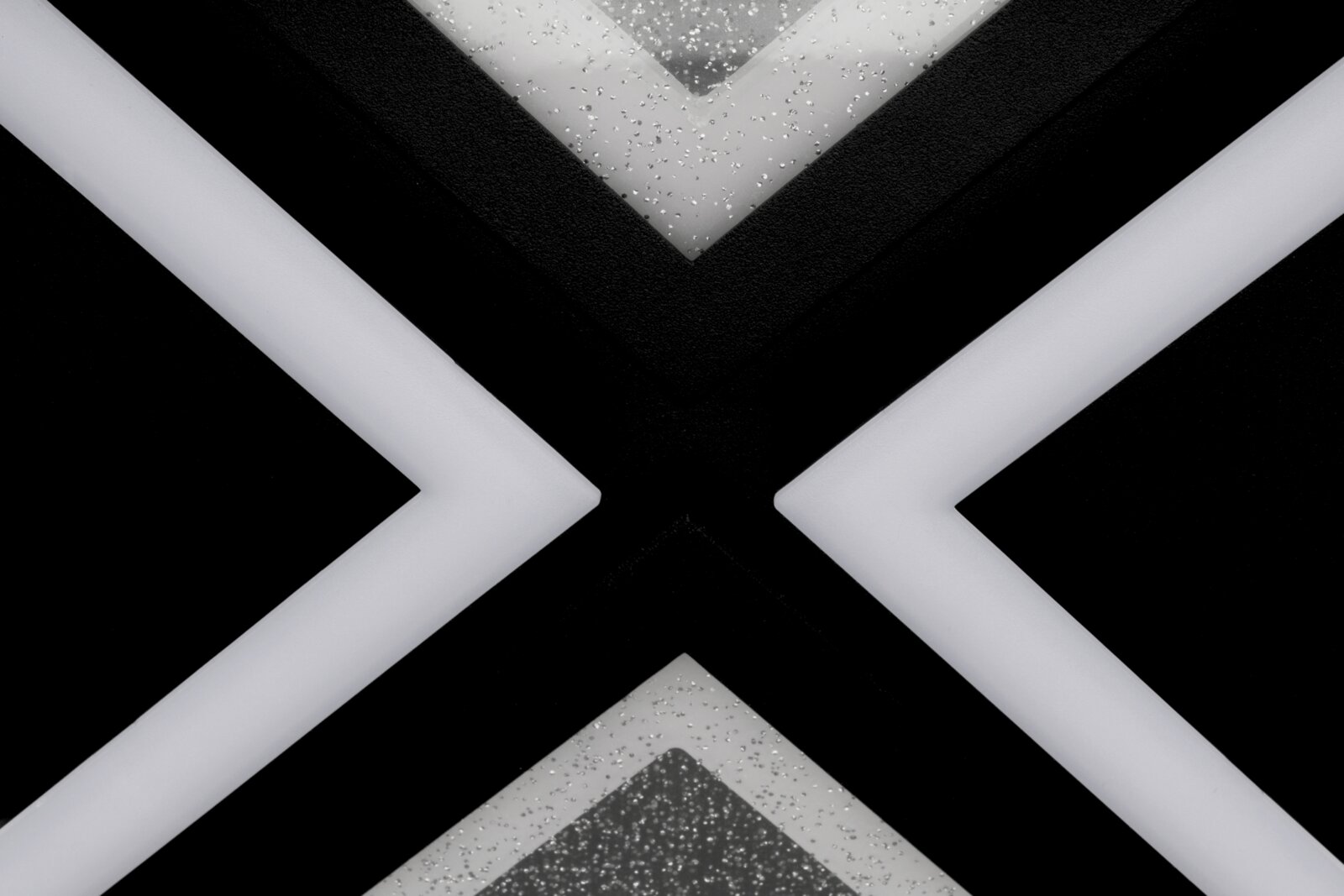 Nahaufnahme einer modernen LED-Deckenleuchte mit geometrischem Design und glitzernden Details, von unten betrachtet.