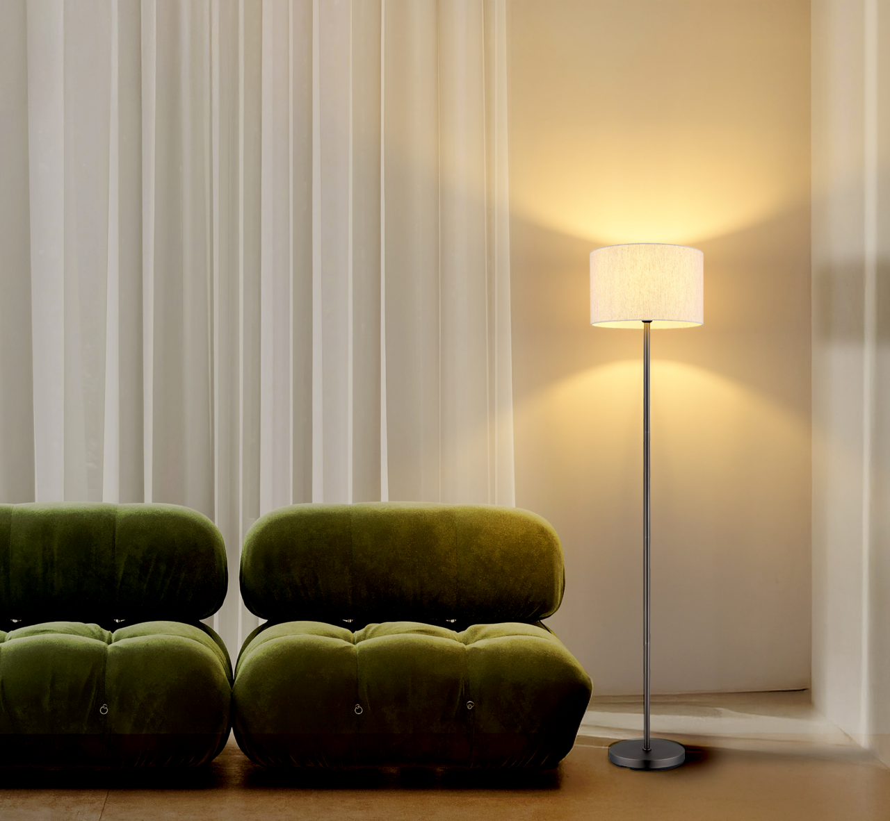 NOWA Staande lamp THEA Moderne Stehleuchte mit schlichtem Design, beleuchtet in einem gemütlichen Wohnzimmer neben einem grünen Sofa, seitliche Perspektive.