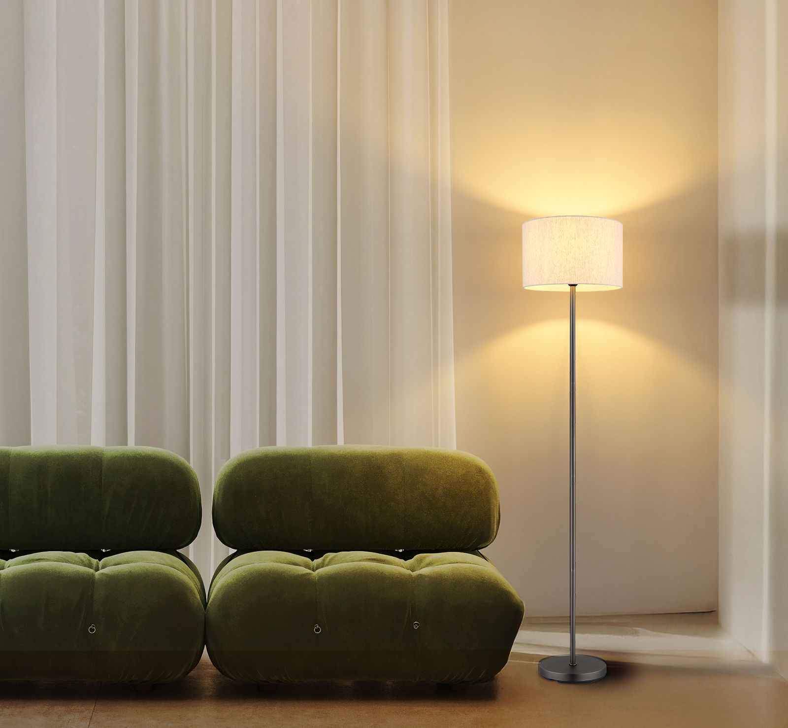 Moderne Stehleuchte mit schlichtem Design, beleuchtet in einem gemütlichen Wohnzimmer neben einem grünen Sofa, seitliche Perspektive.