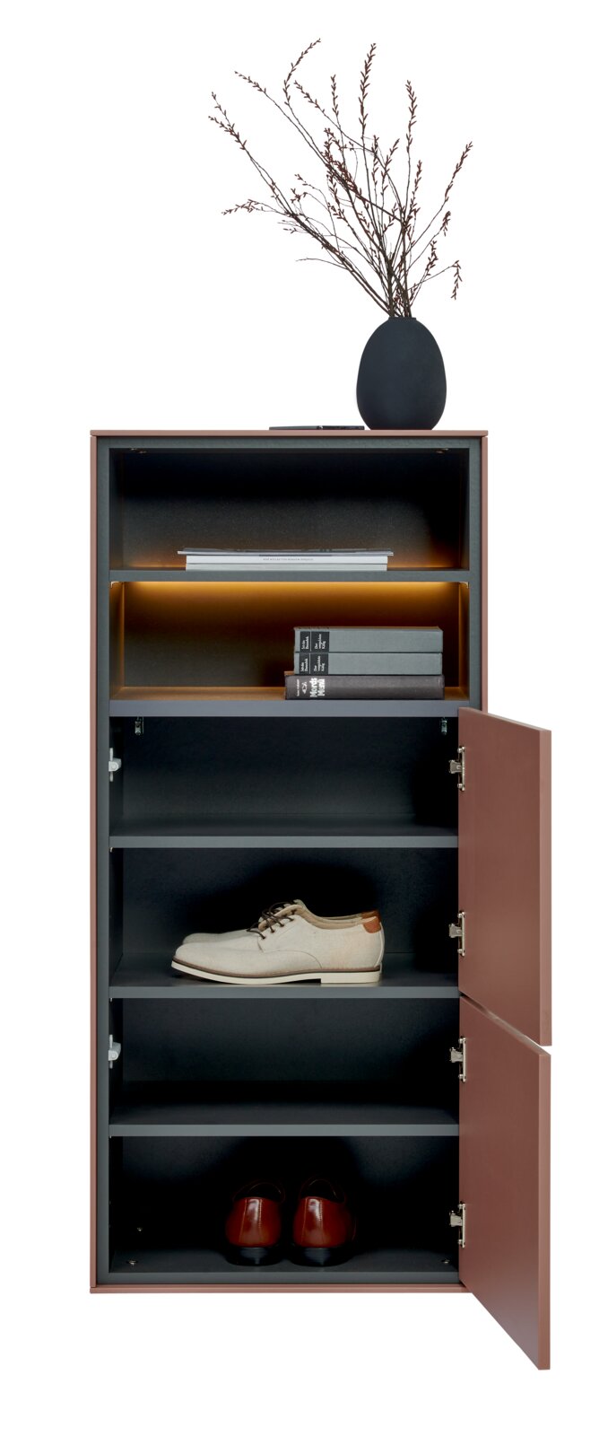 Schmaler, hoher Schuhschrank in Rosébraun mit dunklem Innenraum und warm beleuchteten Fächern, rechte Türen geöffnet; vorne freigestellt auf weißem Hintergrund, mit Vase und Zweigen oben sowie Schuhen und Büchern im Inneren