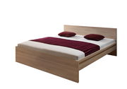 Holzbett mit Kopfteil, zwei roten Kissen und einer roten Decke, seitliche Perspektive