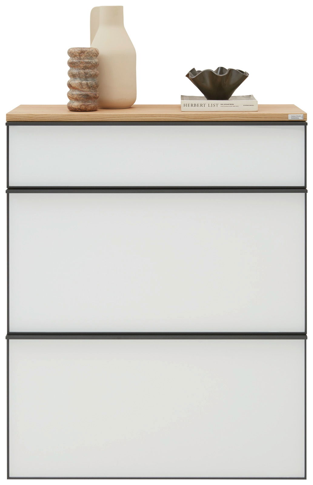 Moderner Hängeschuhschrank mit drei weißen Schubladen und einer Holzoberfläche, dekoriert mit einer Vase, einem Buch und einer Schale, Frontalansicht.