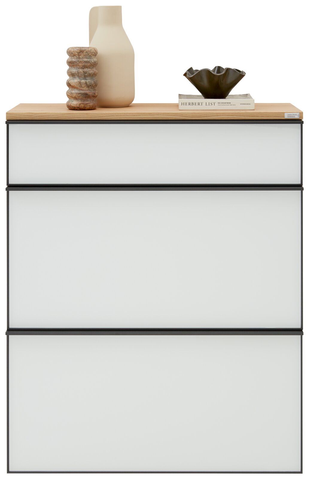 Moderner Hängeschuhschrank mit drei weißen Schubladen und einer Holzoberfläche, dekoriert mit einer Vase, einem Buch und einer Schale, Frontalansicht.