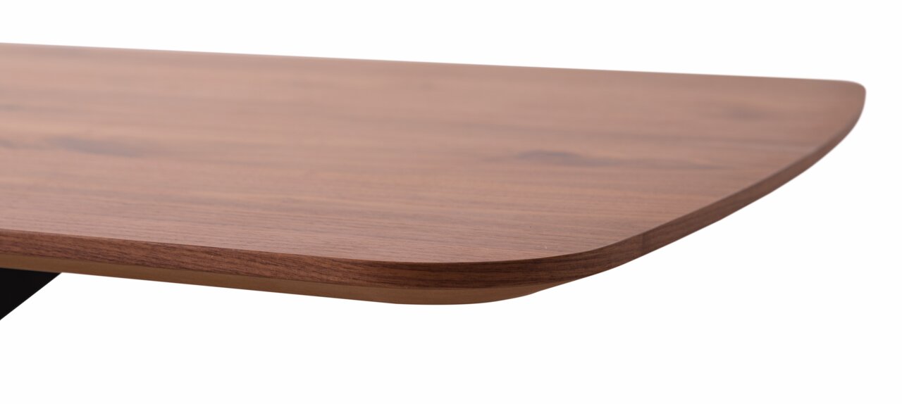 Nahaufnahme einer Tischkante aus Holz mit abgerundeter Ecke, seitliche Perspektive.