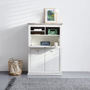 Witte secretaire met klapdeur, open vakken en kastdeuren, gefotografeerd vanaf de voorkant. Versierd met een lamp en een foto op het blad.