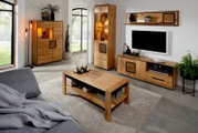 Moderne woonkamerset van massief hout met verlichte vitrinekast, dressoir/tv-meubel, wandrek en salontafel op een licht tapijt, gefotografeerd in een schuin vooraanzicht (licht perspectief van links).