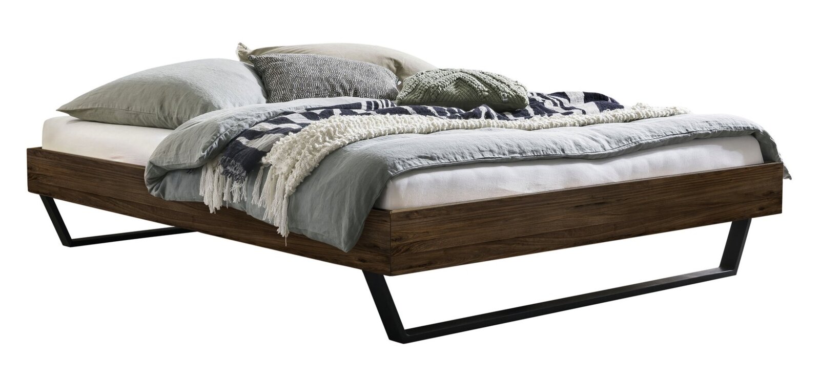 Modern bedframe van donker hout met zwarte metalen sledepoten, voorzien van grijs beddengoed en kussens, perspectivisch aanzicht schuin van linksvoor.
