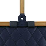 Nahaufnahme eines dunkelblauen, gesteppten Carrybag-Rahmens mit goldfarbenen Griffen, von vorne betrachtet.