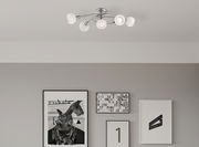 Moderne Deckenleuchte mit fünf weißen Lampenschirmen, von unten betrachtet.