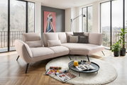 Beige Longchairkombination in modernem Wohnzimmer mit großen Fenstern, Kunstwerk an der Wand und Pflanzen, aus seitlicher Perspektive.