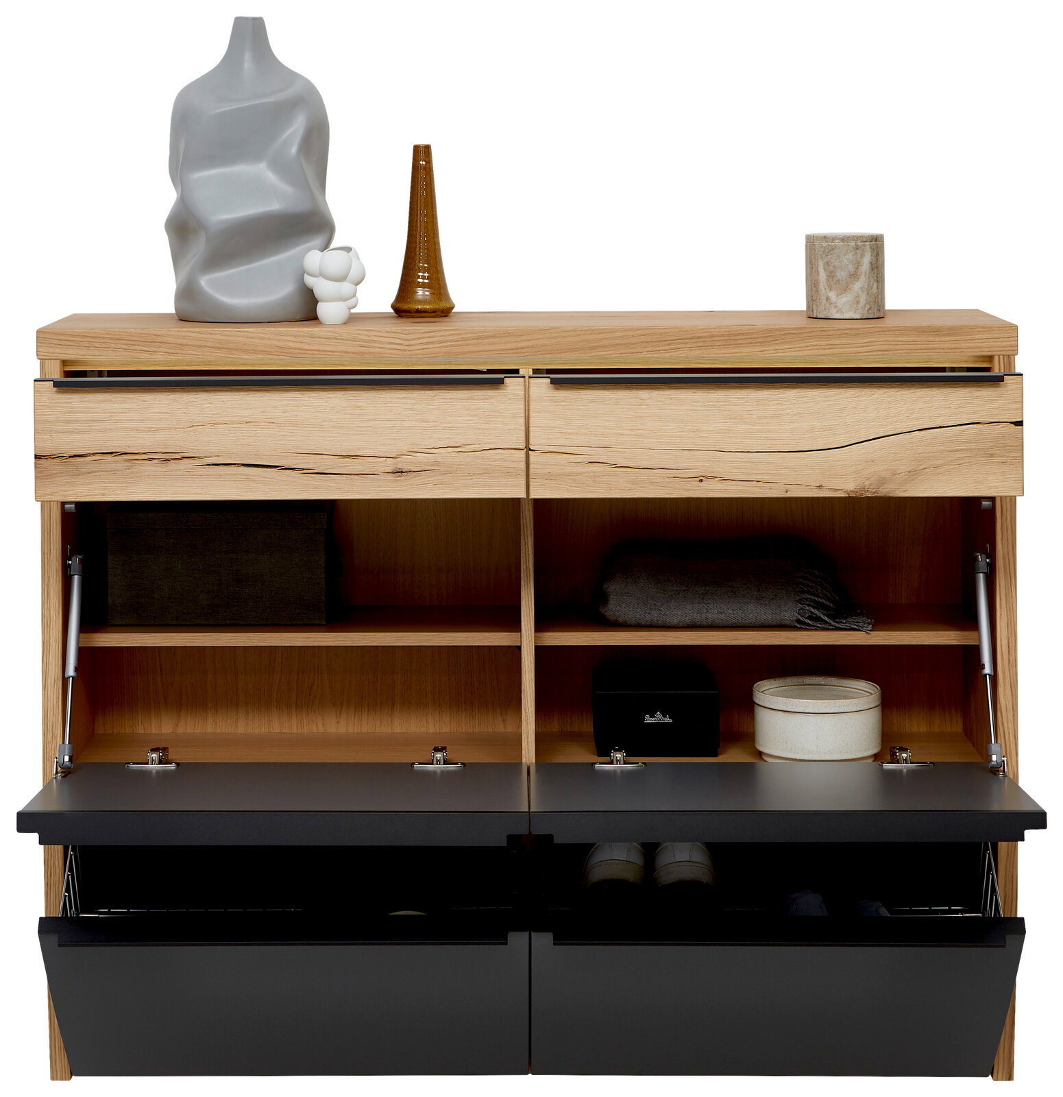 Modernes Schuhschrank-/Sideboard aus hellem Holz mit zwei Schubladen und zwei nach unten klappbaren schwarzen Fronten, geöffnet mit Innenfächern und Schuhkörben; dekoriert mit Vasen und Dose auf der Oberseite, Frontansicht.