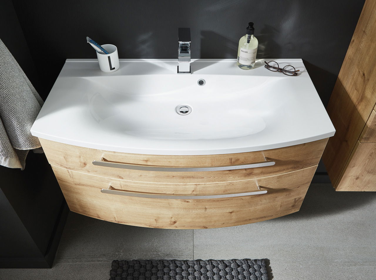 Moderner Badblock mit weißem Waschbecken und Holzunterschrank, aus der Vogelperspektive fotografiert.