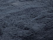 Nahaufnahme eines dunkelgrauen Fellteppichs mit weicher, flauschiger Textur.