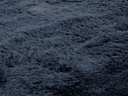 Nahaufnahme eines dunkelgrauen Fellteppichs mit weicher, flauschiger Textur.