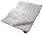 Weiße Bettdecke in diagonaler Perspektive, teilweise gefaltet, mit rotem Etikett.