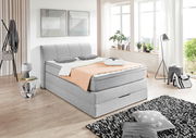 Graues Boxspringbett in modernem Schlafzimmer, seitliche Perspektive