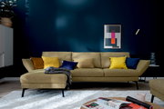 Moderne Longchairkombination in senfgelber Farbe mit bunten Kissen, frontal fotografiert in einem stilvoll eingerichteten Wohnzimmer.