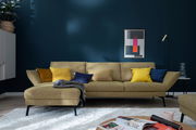 Moderne Longchairkombination in senfgelber Farbe mit bunten Kissen, frontal fotografiert in einem stilvoll eingerichteten Wohnzimmer.