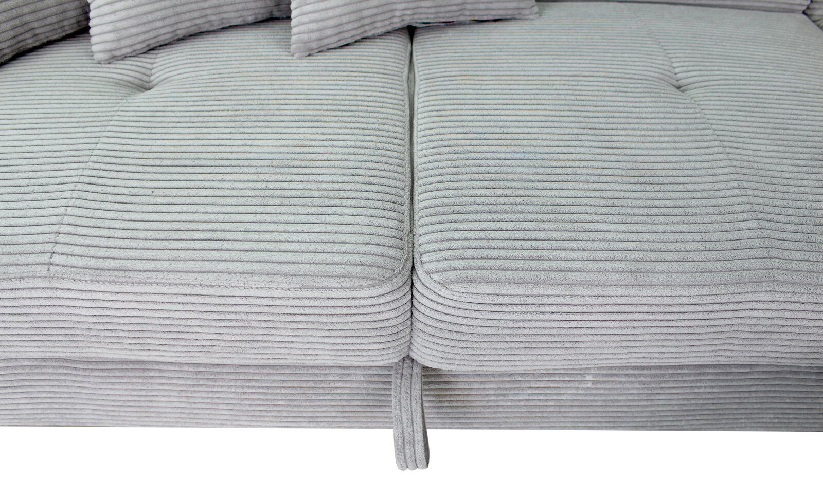 Nahaufnahme einer grauen, gerippten Sofaecke mit Kissen, von oben betrachtet.