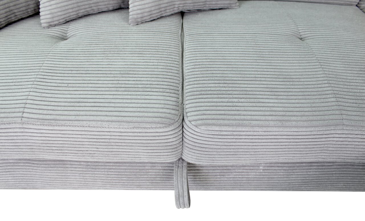 Nahaufnahme einer grauen, gerippten Sofaecke mit Kissen, von oben betrachtet.