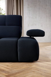 Nahaufnahme einer modernen, dunkelblauen Eckgarnitur mit verstellbarer Armlehne, seitliche Perspektive
