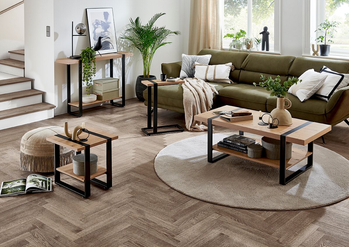 Modernes Wohnzimmer mit Couchtisch, Beistelltischen und Konsolentisch aus Holzoptik mit schwarzem Metallgestell, dekoriert neben grünem Sofa – Perspektive: leicht erhöhte Frontansicht schräg von links.