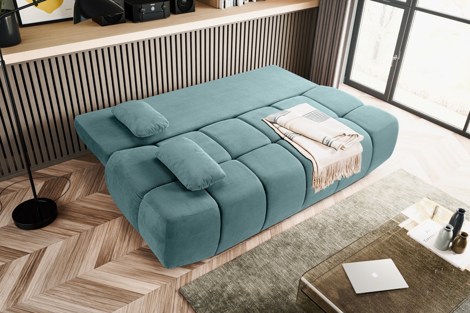 Schlafsofa in Türkis aus der Vogelperspektive, mit zwei Kissen und einer gefalteten Decke.
