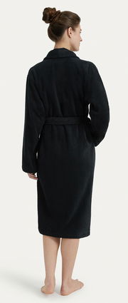 Rückansicht eines schwarzen Bademantels mit Schalkragen, getragen von einer Person mit hochgestecktem Haar.