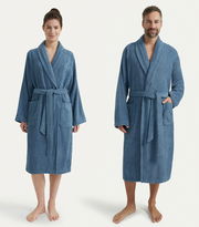 Zwei Personen tragen blaue Bademäntel mit Schalkragen, eine Frau links und ein Mann rechts, beide frontal fotografiert.