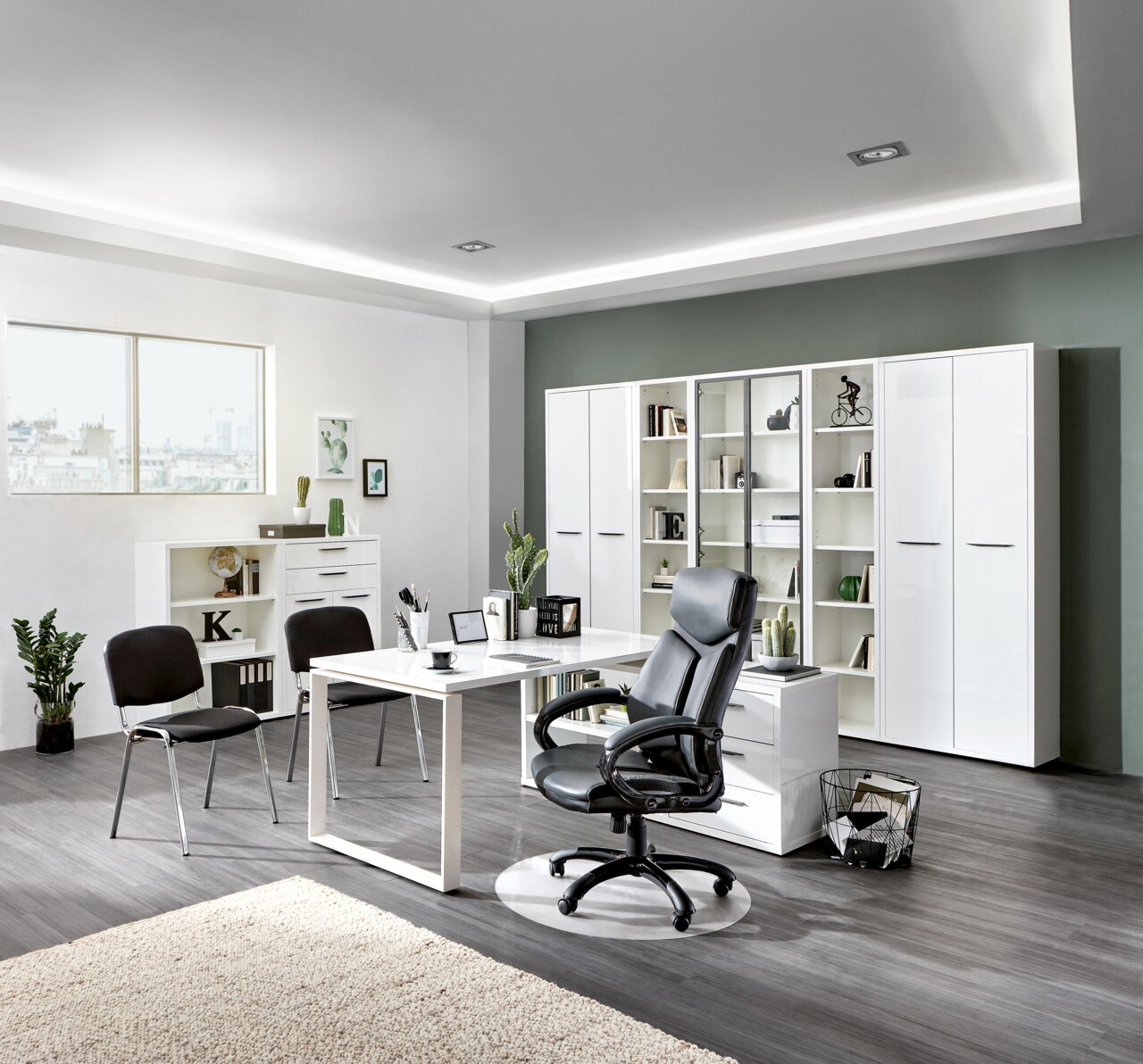Moderne Büroumgebung mit weißem Eck-Schreibtisch, schwarzem Bürostuhl und Regalen im Hintergrund, seitliche Perspektive.