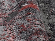 Nahaufnahme eines Designer-Teppichs mit grauen und roten Mustern, perspektivisch von der Seite aufgenommen.