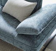 Nahaufnahme einer blauen Longchairkombination mit weichem Stoffbezug und einem beigen Kissen, von oben betrachtet.