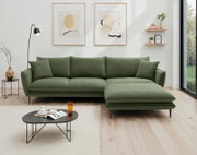 Grünes Ecksofa in modernem Wohnzimmer, Perspektive von vorne.