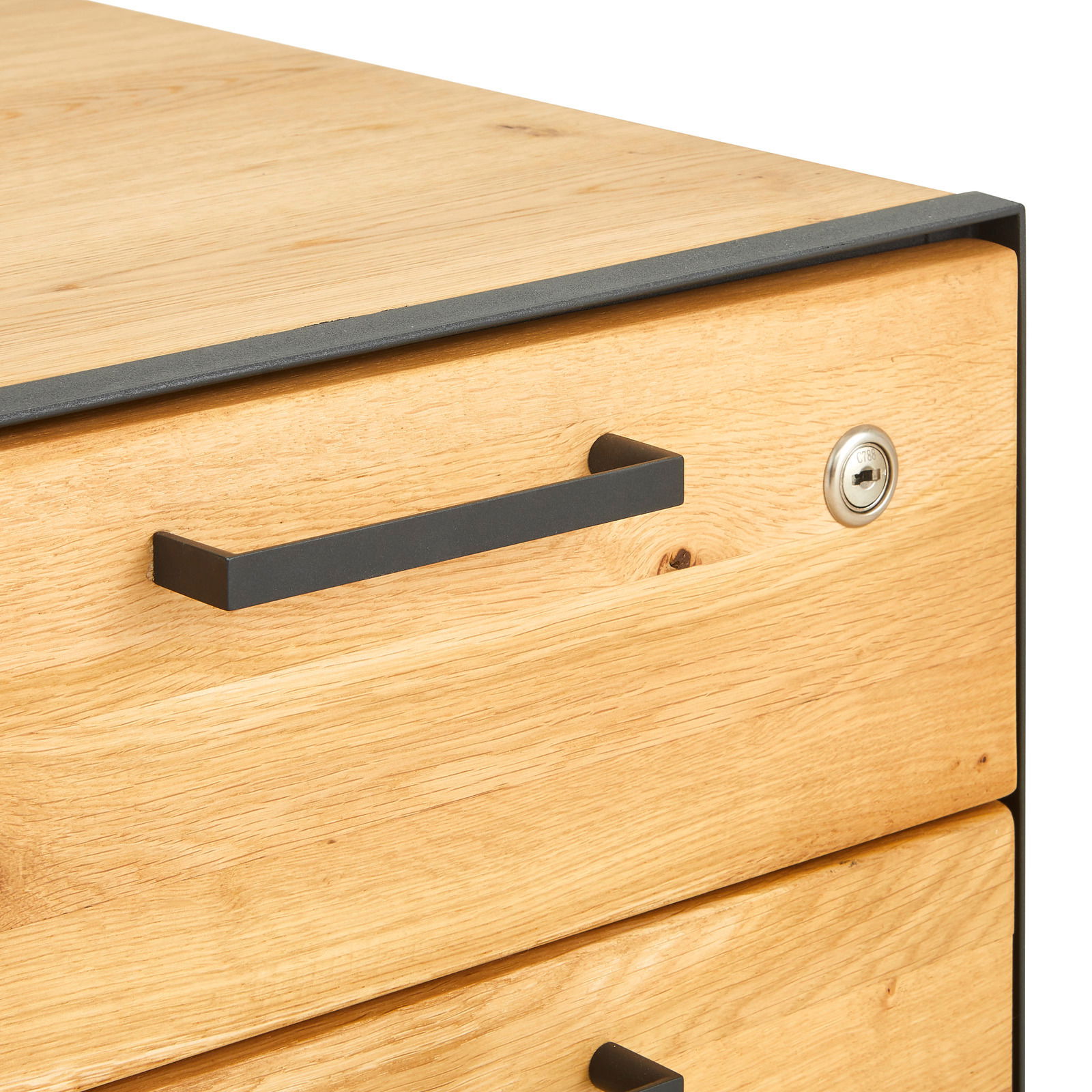 Nahaufnahme eines Rollcontainers aus Holz mit Metallgriff und Schloss, Perspektive von schräg oben.