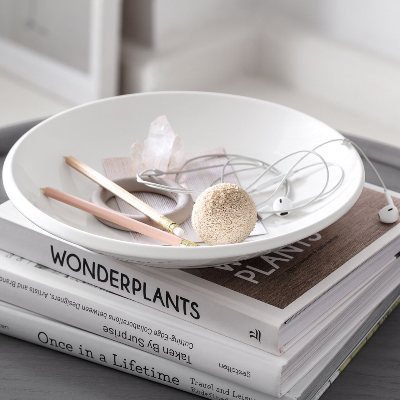 Villeroy & Boch Schale tief NEW MOON Weiße Schale NewMoon 750ml mit Bleistiften, Kopfhörern und Kristall, von oben betrachtet, auf einem Stapel Bücher.
