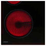 Nahaufnahme eines Glaskeramikkochfelds mit zwei leuchtend roten Kochzonen, von oben betrachtet.