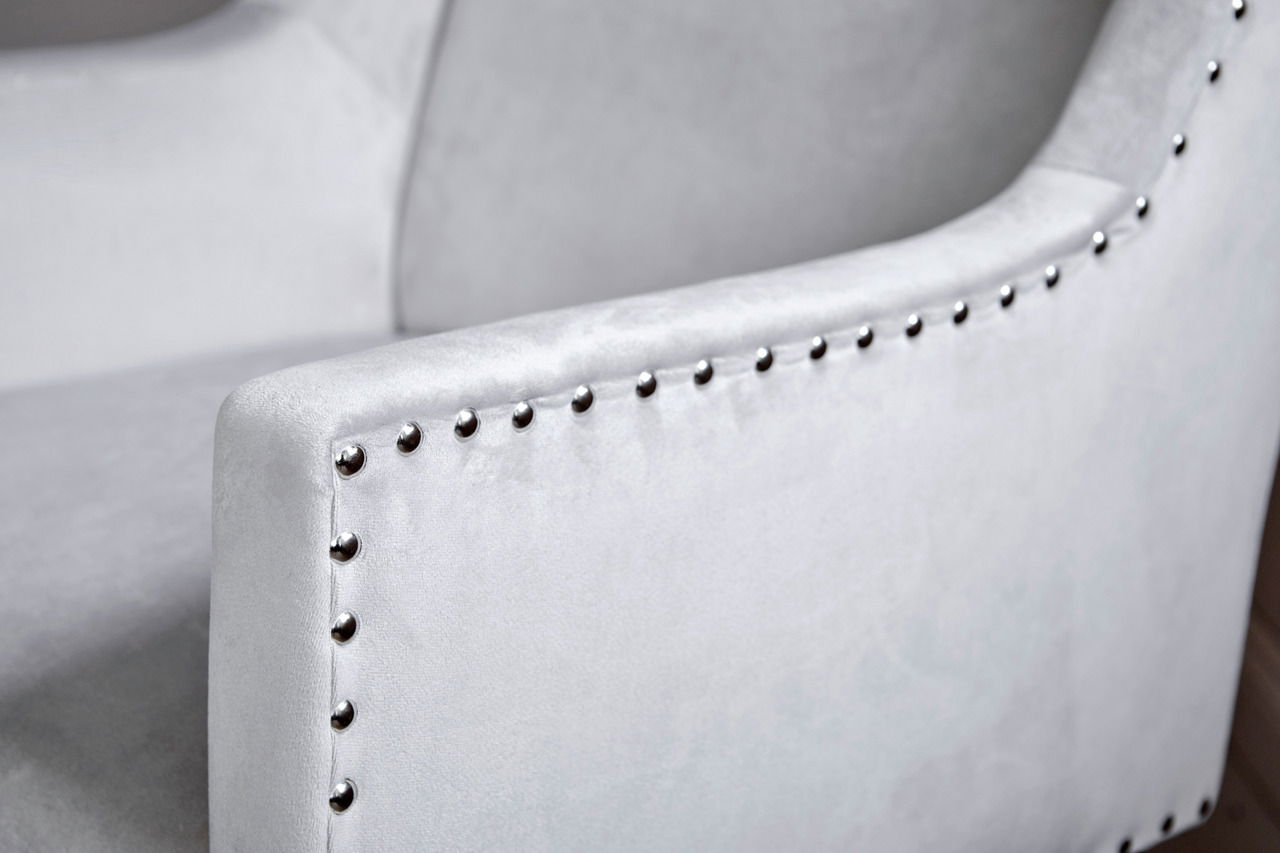 Nahaufnahme eines grauen Stuhls mit Nietenverzierung an der Armlehne, seitliche Perspektive