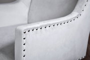 Nahaufnahme eines grauen Stuhls mit Nietenverzierung an der Armlehne, seitliche Perspektive
