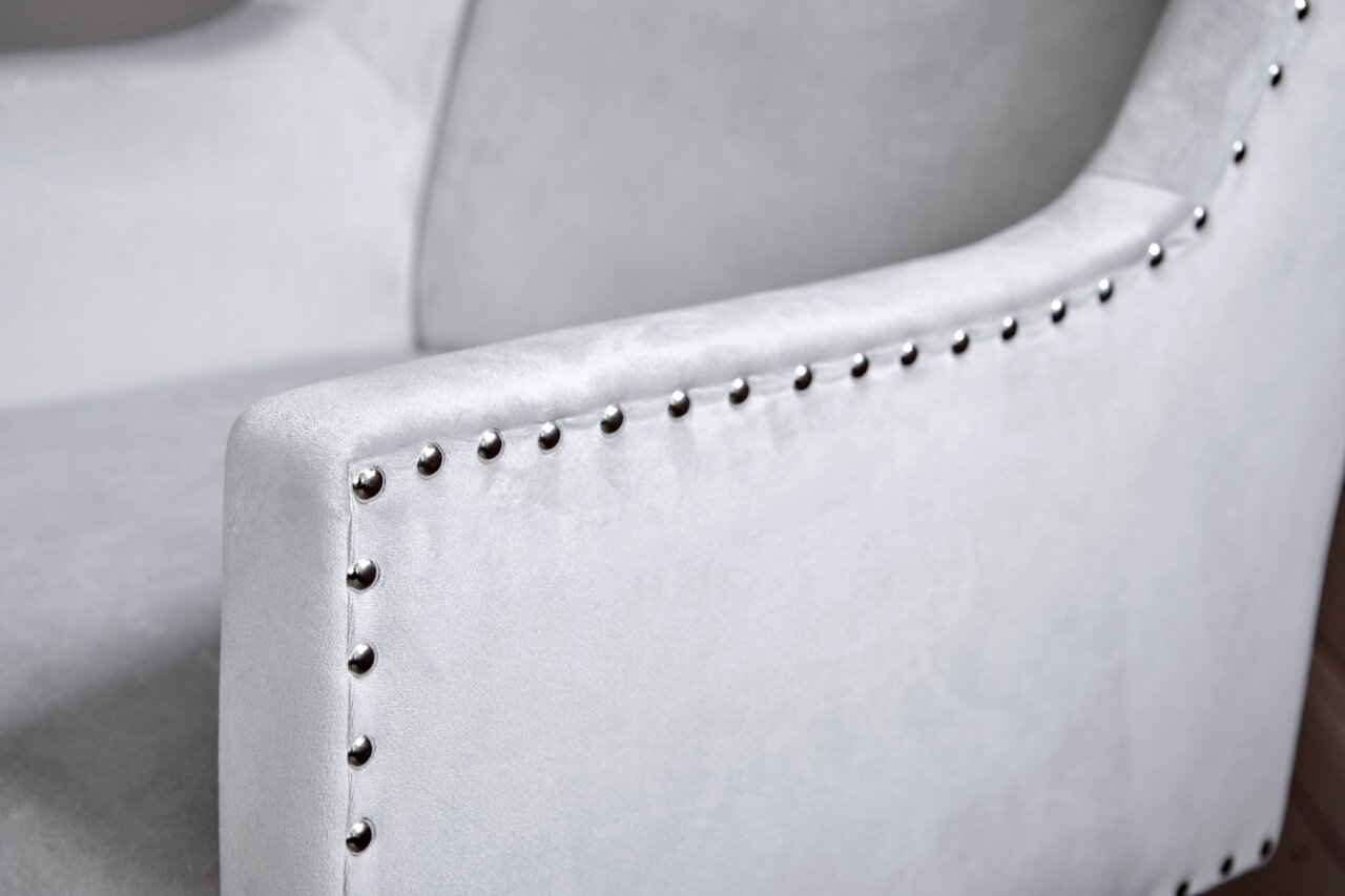 Close-up van een grijze stoel met studs op de armleuning, zijaanzicht