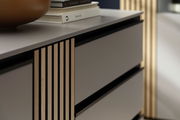 Nahaufnahme eines modernen Sideboards mit Holzlamellen und glatten Schubladenfronten, seitliche Perspektive