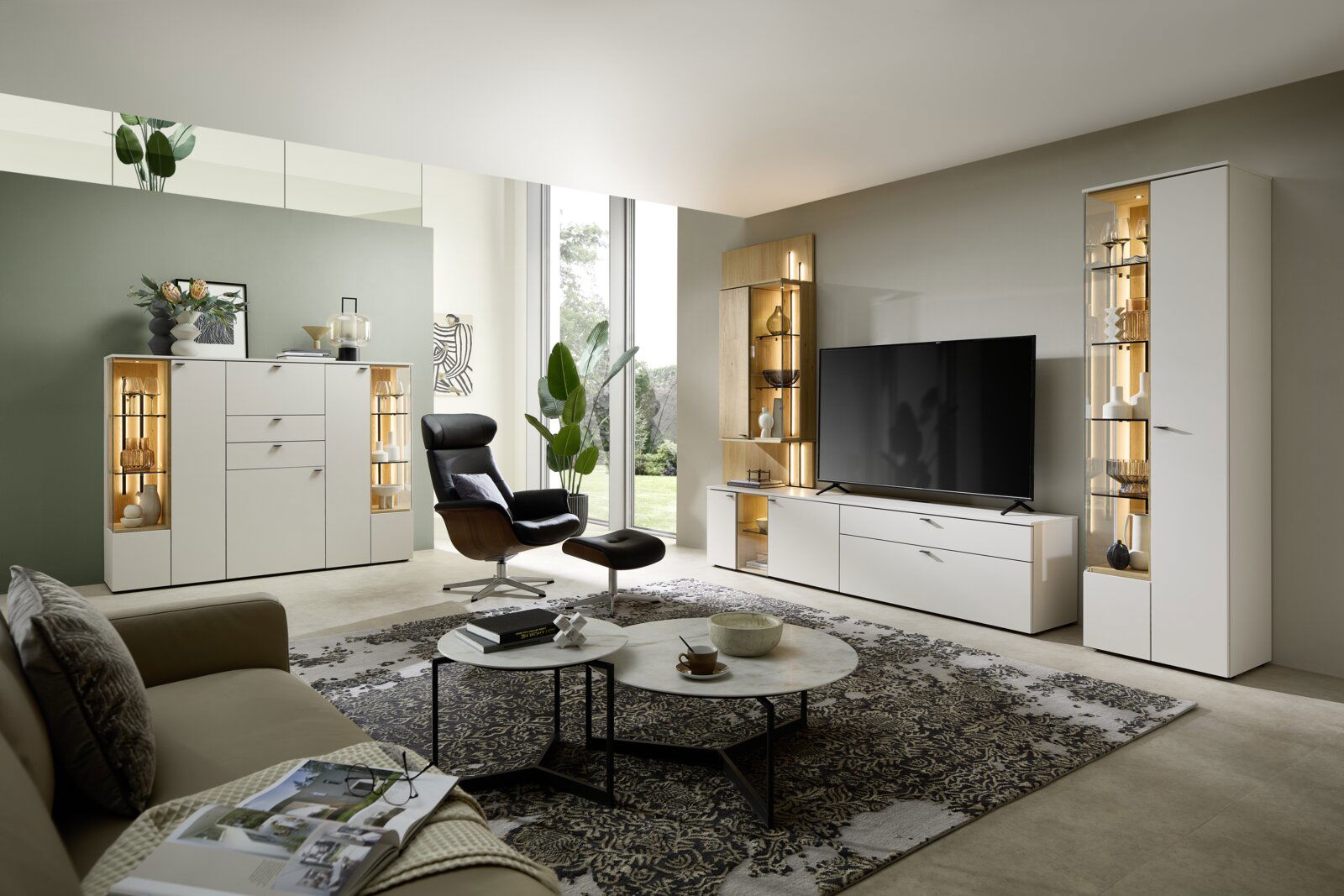 Moderne Wohnzimmeransicht mit eleganter Vitrine, die von vorne gezeigt wird, neben einem großen Fernseher und stilvollen Möbeln.