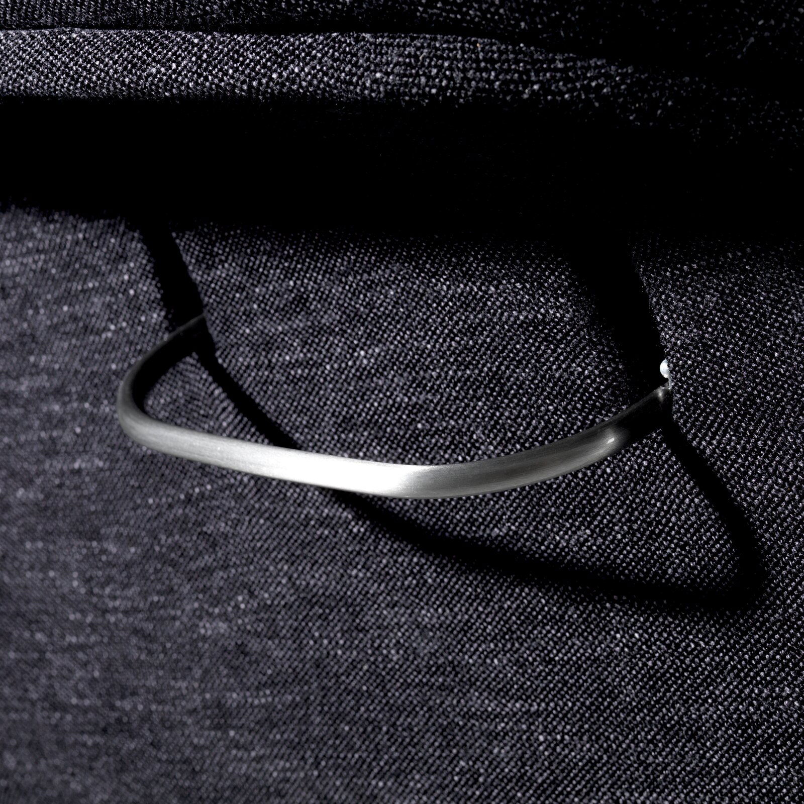 Nahaufnahme eines Relaxsessels mit einem eleganten Metallgriff, seitliche Perspektive.