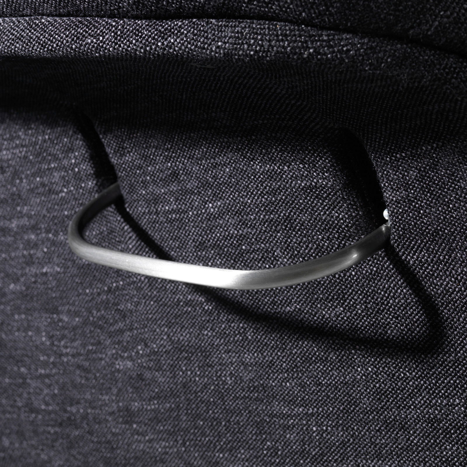 Nahaufnahme eines Relaxsessels mit einem eleganten Metallgriff, seitliche Perspektive.